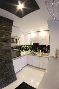 una cocina con armarios blancos y una pared de ladrillo en Black & White, en Racibórz