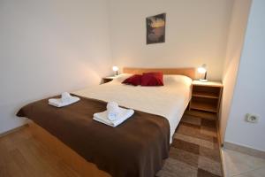 een slaapkamer met een groot bed met handdoeken erop bij Apartments Tavcar in Malinska