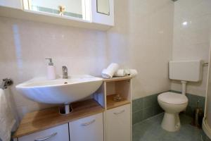 een badkamer met een wastafel en een toilet bij Apartments Tavcar in Malinska +33 foto's