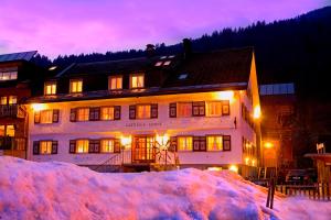 ein großes Gebäude mit einem Schneestapel davor in der Unterkunft Sonne Bezau - Familotel Bregenzerwald in Bezau