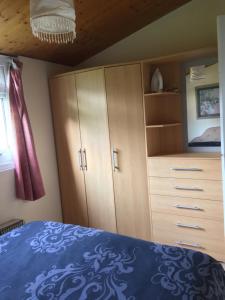 a bedroom with a blue bed and a cabinet at Tranquilo cabanas in Carmarthen