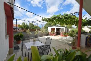 een terras met een tafel, stoelen en planten bij Apartments Tavcar in Malinska