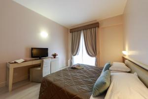 a hotel room with a bed and a television at Hotel Mirasole International in Gaeta