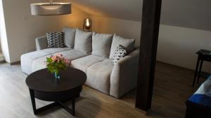 a living room with a white couch and a table at Ringelnatz & Lichtwer- Ferienwohnung Wurzen in Wurzen