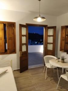 a kitchen with a door and a table and chairs at KOMINOS HOUSES in Patmos +20 photos