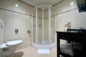 ein Bad mit einer Dusche, einem WC und einem Waschbecken in der Unterkunft Best Western Dam Square Inn in Amsterdam