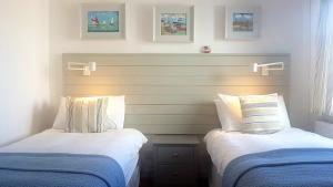 two beds sitting next to each other in a room at TARIAN HAF-3 BED-SEA VIEW BUNGALOW-TREARDDUR BAY in Trearddur