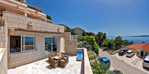 a house with a patio and a view of the water at Apartmani D&D Sosič in Brela