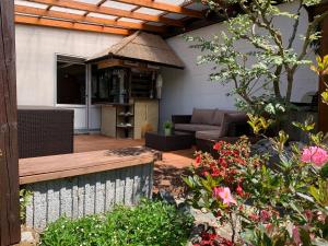 een patio in de achtertuin met een bank en een tuinhuisje bij Dokazien in Waldems