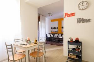 een eetkamer met een tafel en stoelen en een klok bij Residence Griffoni in Bologna