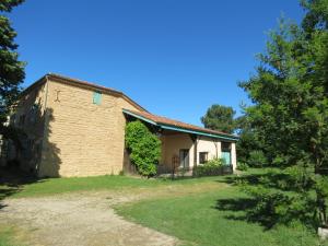 an old brick building with trees in front of it at Les Hortensias in Caumont-sur-Garonne