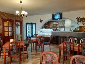 a dining room with tables and chairs and a tv at Penzion - Restaurant U Zámku in Bečov nad Teplou