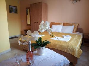 a hotel room with a bed and a table with flowers at Willa ANNA in Pustkowo