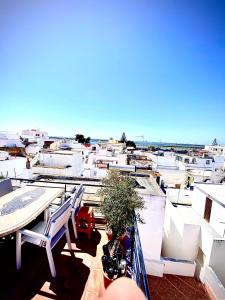 a balcony with chairs and a motorcycle on a building at Zenit Olhao Bed & Breakfast in Olhão