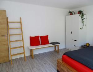 a bedroom with two red pillows on a bench at Ferienwohnung beim Burgberg in Bad Abbach