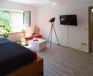 a bedroom with a bed and a flat screen tv at Ferienwohnung beim Burgberg in Bad Abbach