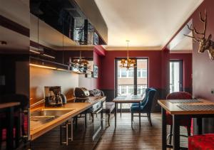 una cocina con paredes rojas, mesas y sillas en Haverkamp Suites, en Bremerhaven