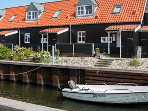 łódź przywiązana do przystani przed domami w obiekcie 5 person holiday home in Juelsminde w mieście Juelsminde