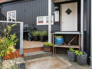 dom z drzwiami i werandą z roślinami w obiekcie 5 person holiday home in Juelsminde w mieście Juelsminde