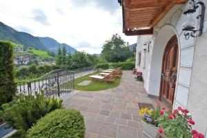 einen Balkon eines Gebäudes mit einem Tisch und Bänken in der Unterkunft Villa sulla passeggiata in St. Ulrich in Gröden