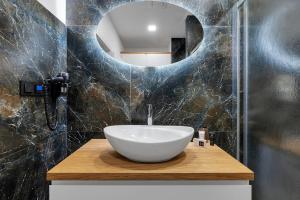 a bathroom with a bowl sink and a mirror at Nový designový apartmán s klimatizací in Rychnov nad Kněžnou