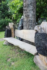 un banco de madera sentado junto a un árbol en Ferienhaus Franz - an der Elbe, mit großem Garten, en Pirna