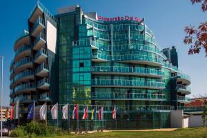 a tall glass building with a sign on it at Hotel Primorsko Del Sol in Primorsko