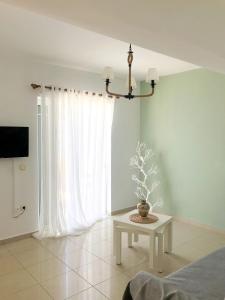 a living room with a table and a window at AQUALIA Apartment 1 in Karpathos