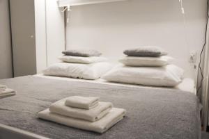 four white towels are stacked on a bed at Apartment Nona in Šmrika
