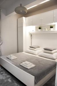 a white bedroom with two beds with towels on them at Apartment Nona in Šmrika