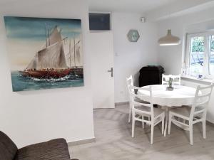 a dining room with a white table and a painting of a ship at Apartment Nona in Šmrika