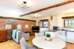 a kitchen and living room with a table and chairs at Knockerdown Cottages in Ashbourne