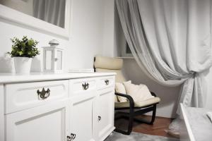 ein weißes Bad mit einem weißen Schrank und einem Stuhl in der Unterkunft Apartment Nona in Šmrika