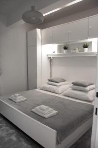 ein weißes Schlafzimmer mit einem großen Bett mit Handtüchern darauf in der Unterkunft Apartment Nona in Šmrika