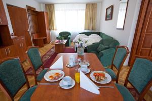 una sala da pranzo con tavolo e cibo di HELIOS Hotel Apartments a Budapest