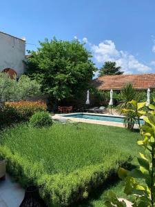 un jardín con piscina y una casa en Le petit hotel, en Saint-Rémy-de-Provence