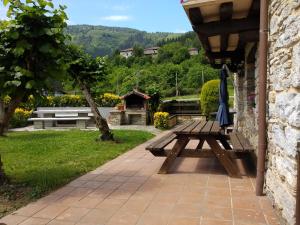 - une table de pique-nique en bois assise sur une terrasse dans l'établissement Goikoetxe Baserria, à Zeanuri
