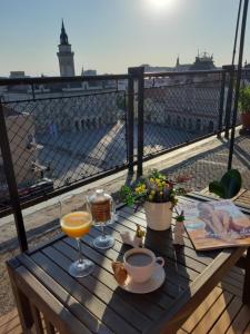 a table with two glasses of orange juice on a balcony at Apartment Zorana-Center in Novi Sad