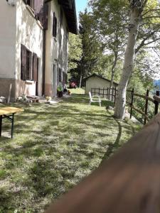 a yard with a wooden fence and a table and chair at Azzone Cascina nel verde in Azzone