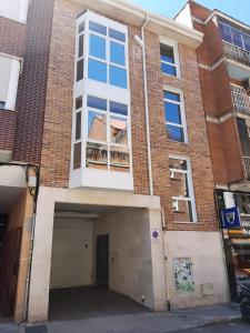 un edificio de ladrillo con una gran ventana y un garaje en APARTAMENTOS SANTA JULIANA, en Madrid