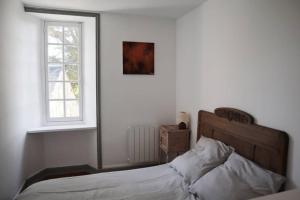 A bed or beds in a room at Le Clos Loisel Maison ancienne et jardin bucolique