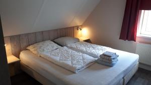 a bedroom with a white bed with two pillows at Appartement Esta in Buren