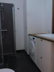 uma casa de banho com um chuveiro e uma máquina de lavar roupa em ApartmentInCopenhagen Apartment 1323 em Copenhaga