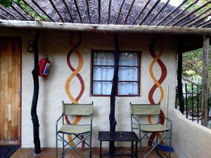 twee stoelen en een tafel voor een huis bij Discovery Bed and Breakfast in Maun