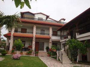 a building with stairs and flowers in a yard at Simos Apartments in Korinos