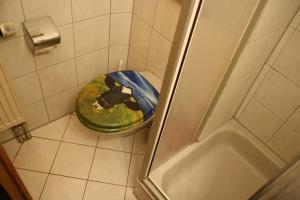 a bathroom with a toilet with a dog laying on it at Landhaus Eibelesee in Oberstaufen