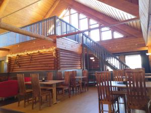 a restaurant with wooden walls and tables and chairs at Hotelli Kolari in Kolari