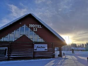 een gebouw met een bord in de sneeuw bij Hotelli Kolari in Kolari