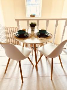 a dining room table with two white chairs at Barackvirág Vendégház in Tihany