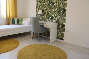 a bedroom with a desk with a chair and a couch at Holiday Apartment in Mostar